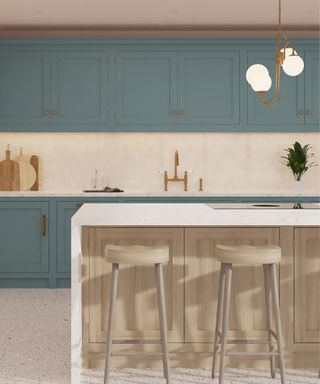 A white waterfall kitchen island with ashy wood back panels and stools and blue cabinets behind it with marble countertops