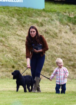 Kate Middleton is a known dog lover, being seen here playing with their former family dog, Lupo, and niece Savannah Phillips