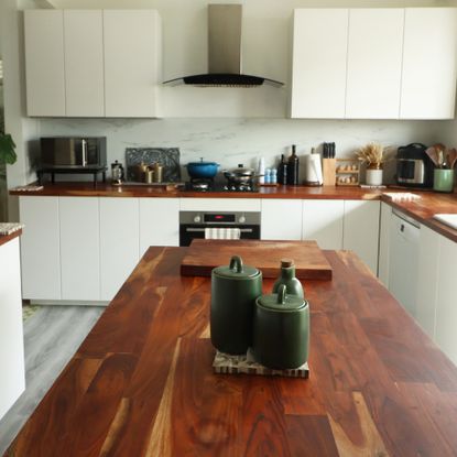 White kitchen with counter-top appliances and wooden worktops