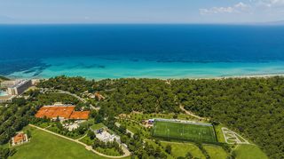 An aerial shot showing the tennis courts and football pitch at Sani Resort, surrounded by forest