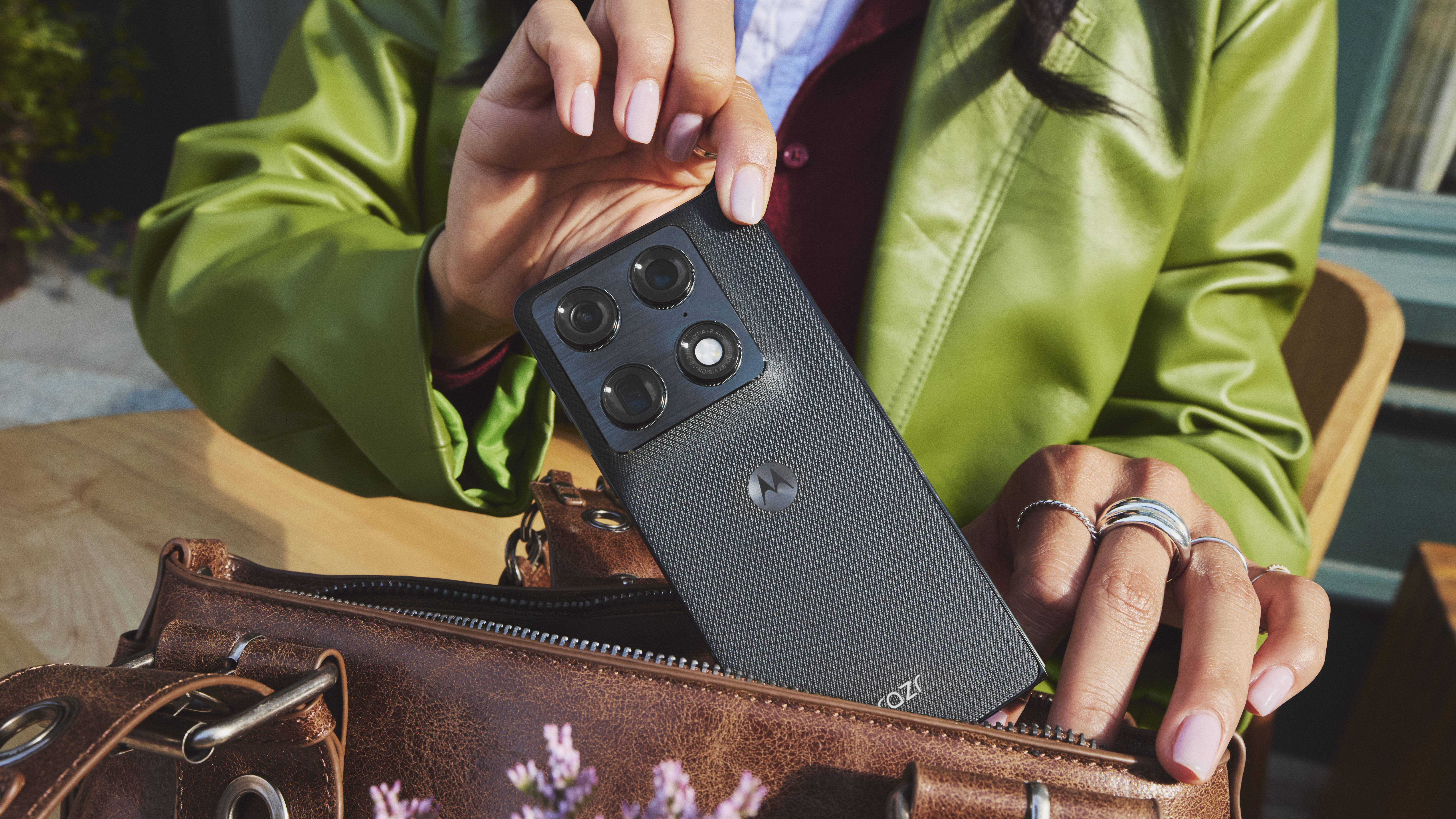 A Motorola Razr Fold being put away in a bag by a woman