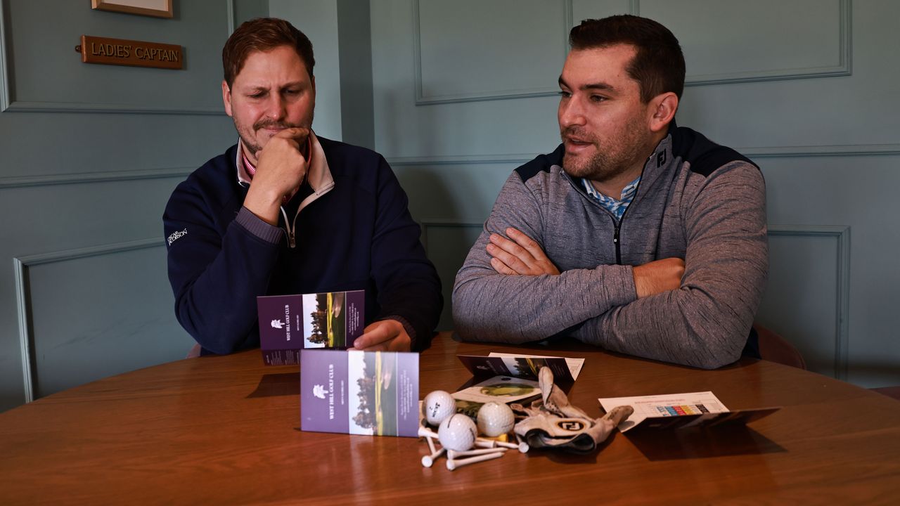 Two golfers in a clubhouse looking at scorecards