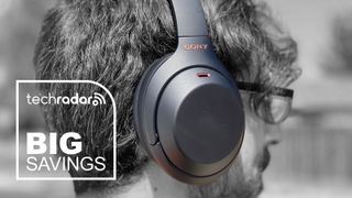 A man wearing the Sony WH-1000XM4 headphones. "Big Savings" text in white is in the bottom left.