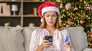 A holiday shopper looking at their smartphone in shock
