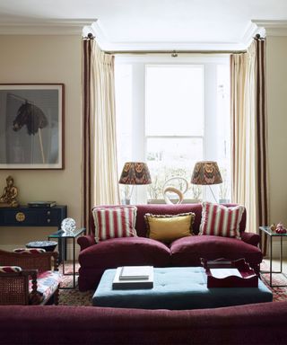 neutral traditional victorian living room with vintage and antique decor and two matching aubergine purple couches