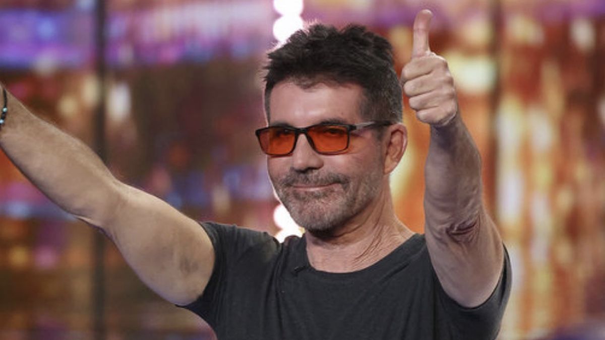 Simon Cowell in orange-tinted glasses giving the crowd two thumbs up on America&#039;s Got Talent