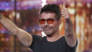 Simon Cowell in orange-tinted glasses giving the crowd two thumbs up on America&#039;s Got Talent