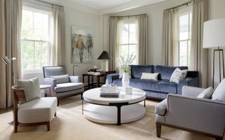 A transitional style living room with blue sofas and neutral walls