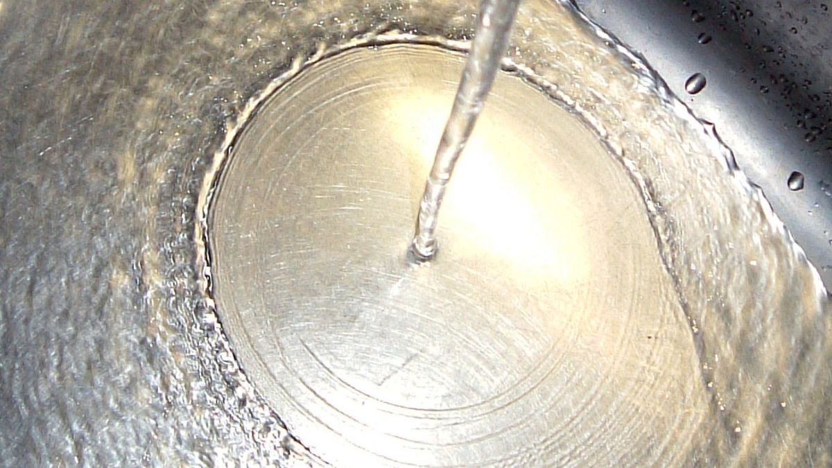 將水倒入金屬盆中。在深池中形成淺環。