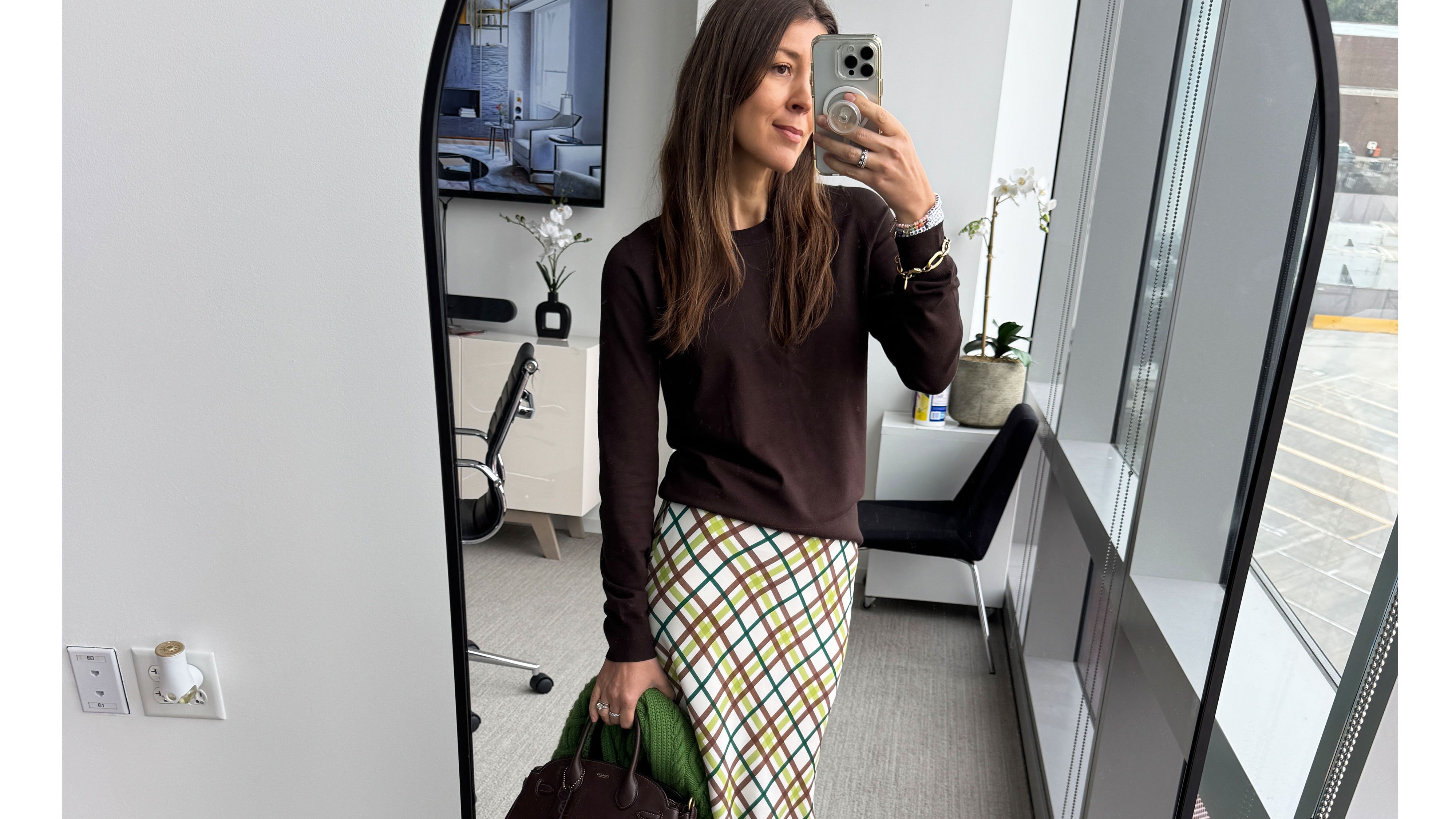 Woman in brown sweater and plaid skirt