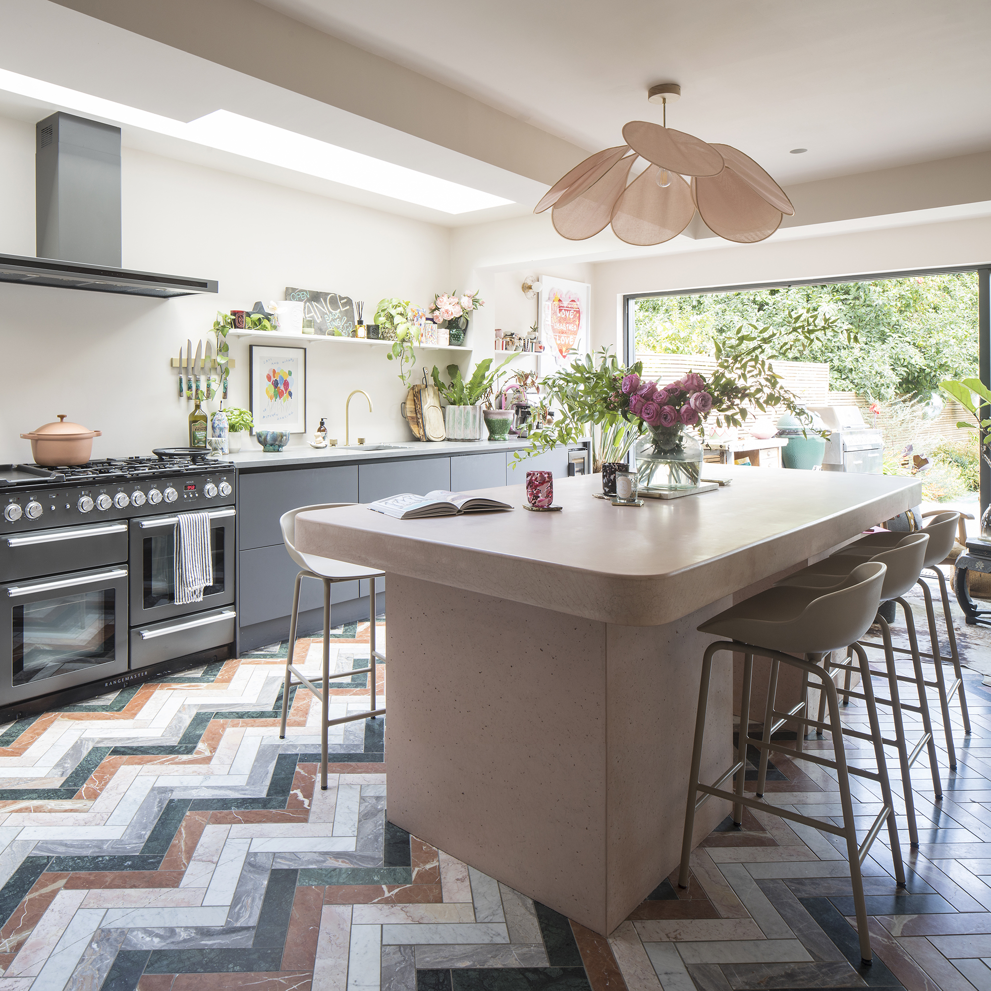 Kitchen with pink island and colourful chevron flooring