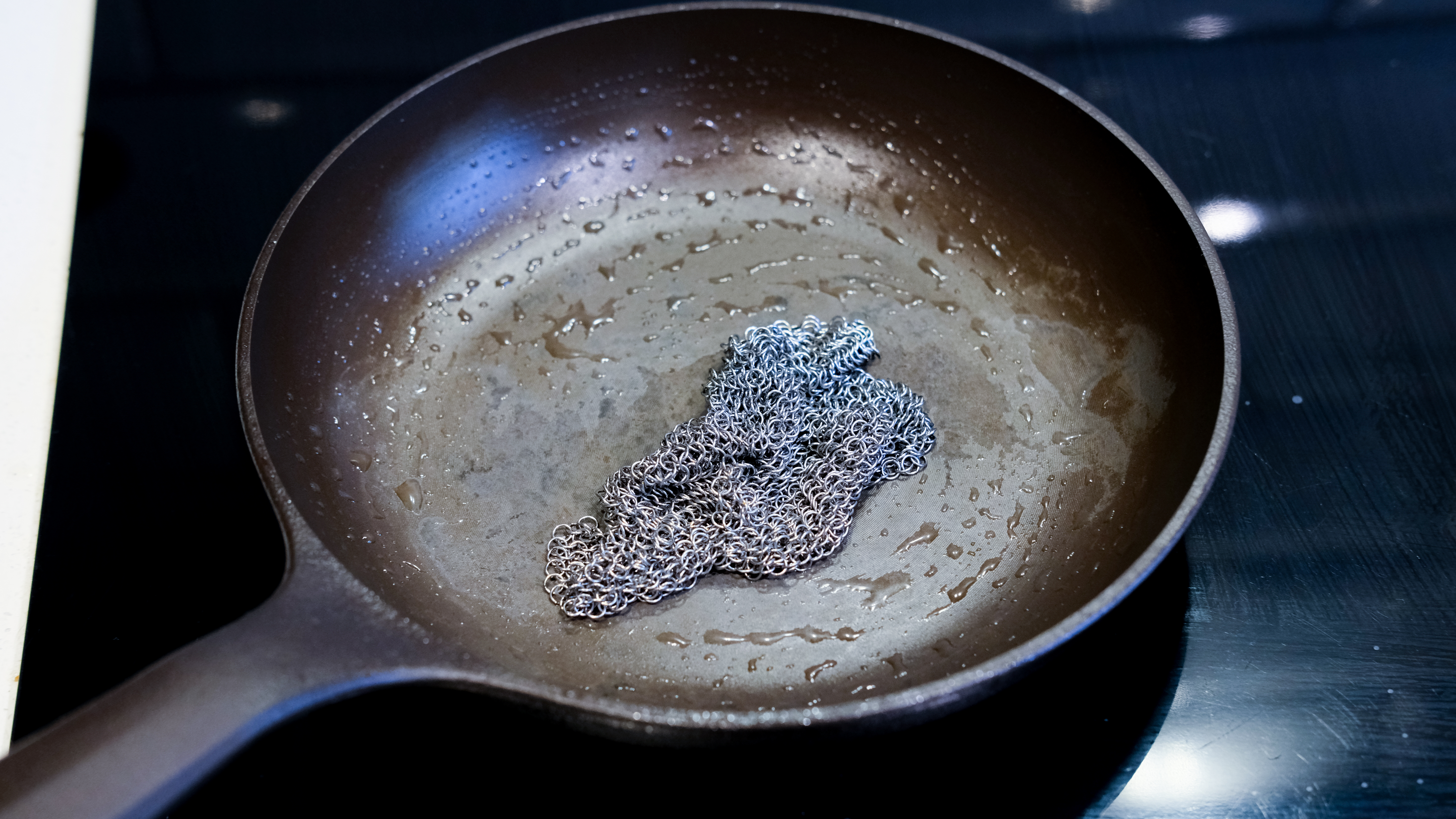The Field Company Skillet being cleaned with a chainmail scourer