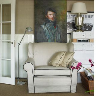 living room with painting on wall and cushion on chair