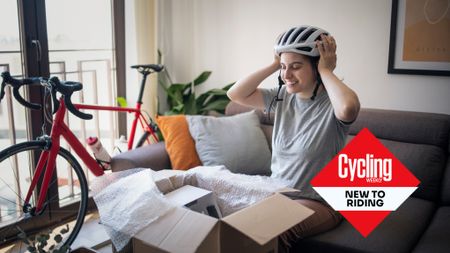 New cyclist tries on helmet with new bike in the background