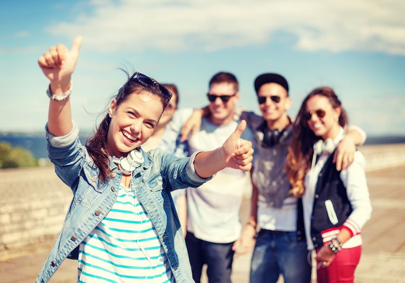 group of happy teenagers on the beach