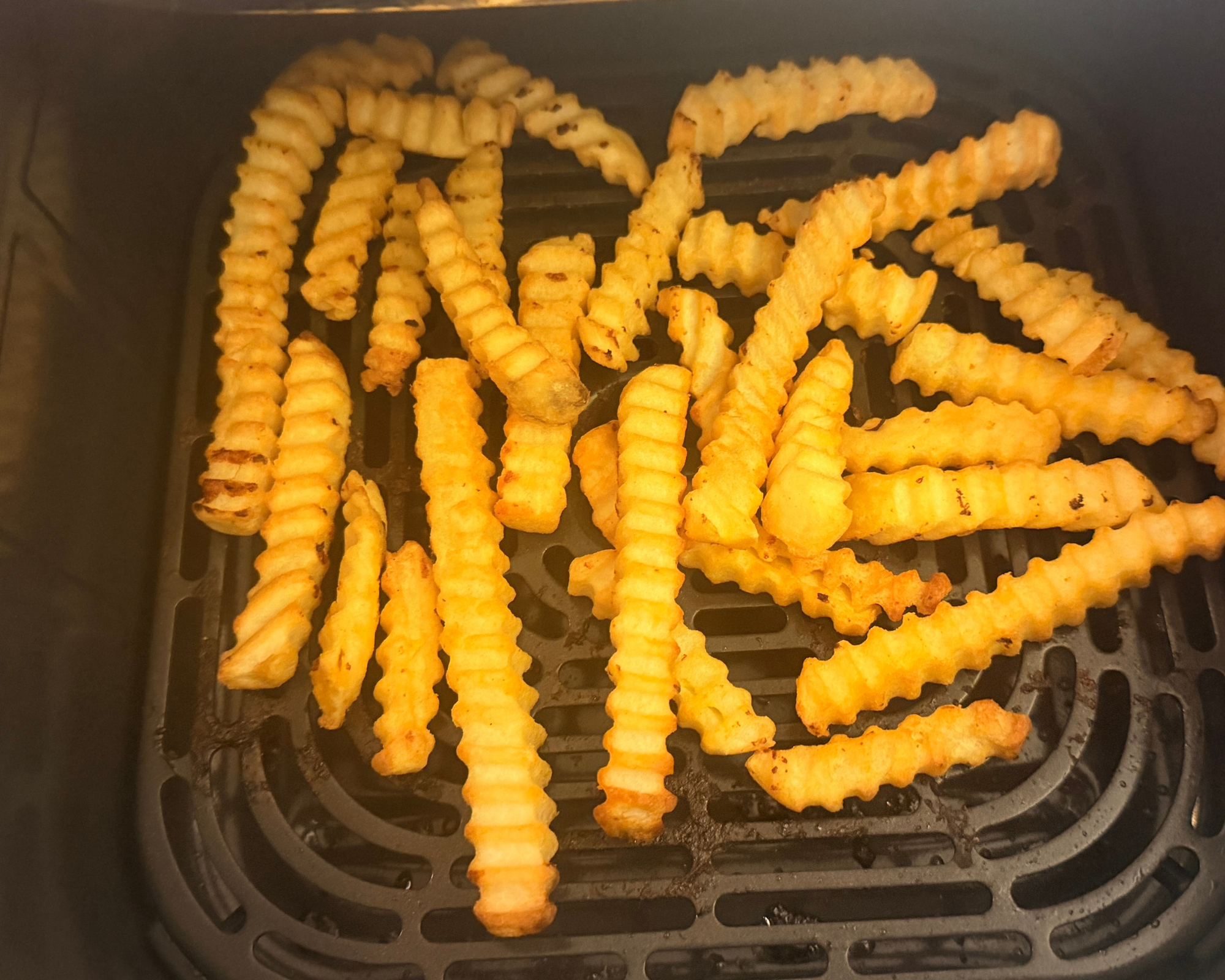 Crispy French fries in an air fryer basket