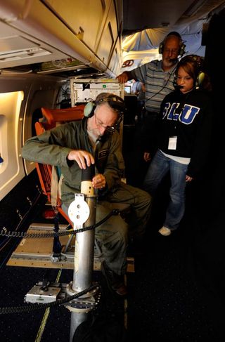 Errol Korn, seated left, deploys a dropsonde experiment over the Gulf of Mexico during a research flight on NASA's DC-8 aircraft.