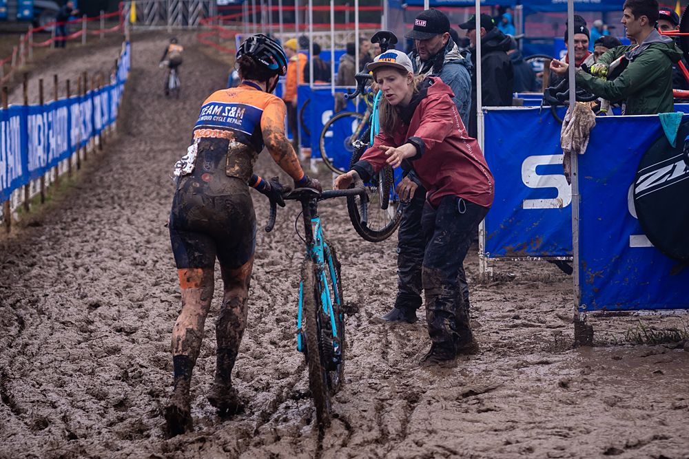 Brenna Wrye-Simpson takes a bike in the muddy mechanic's pit