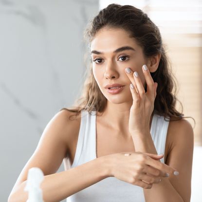 young woman applying skincare