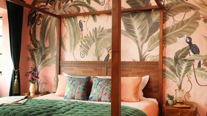 Bedroom with tropical mural wallpaper behind bedhead