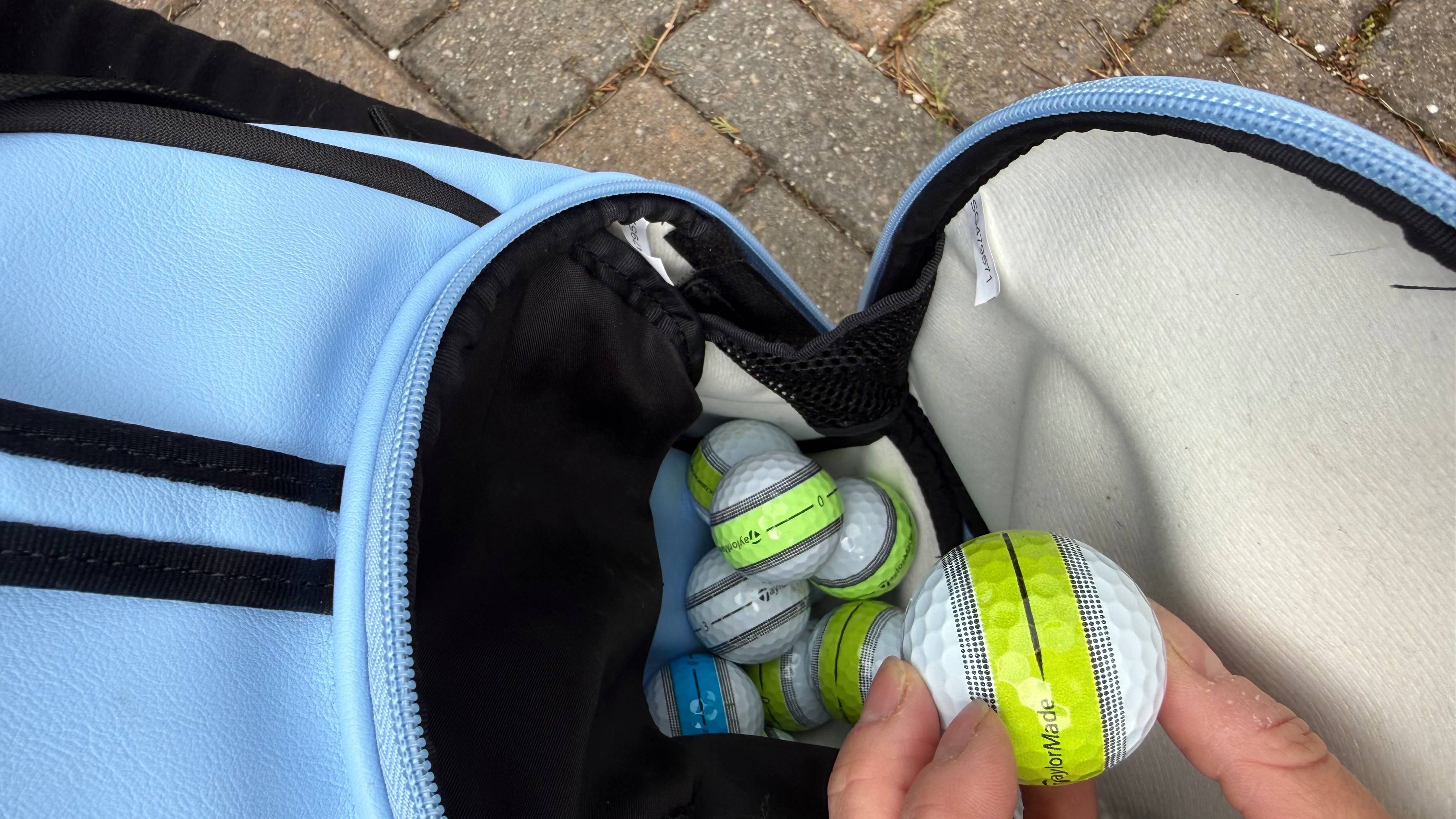 Katie Dawkins taking a ball out of the ball pocket in her golf bag