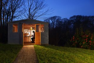 man working in shed home office in the dark