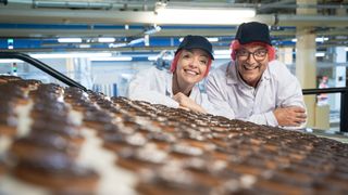 Cherry Healey and Gregg Wallace behind a conveyor belt of Jaffa Cakes for Inside the Factory