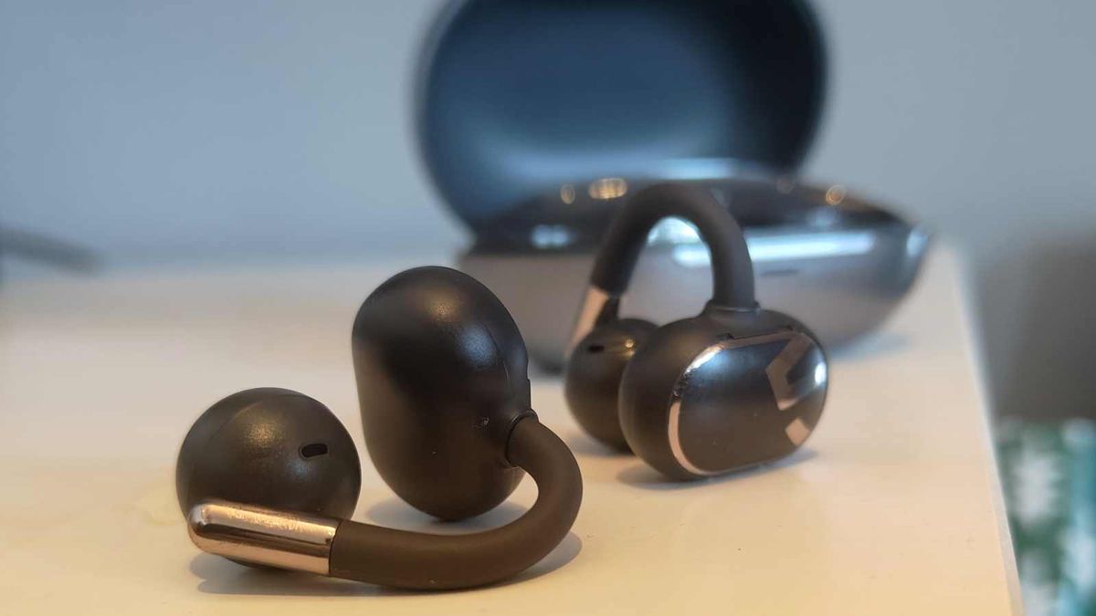 The Soundpeats Clip1 buds on a table next to the case.