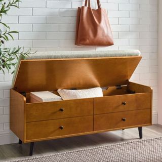 Storage bench with lid open in hallway and cushions peeking out
