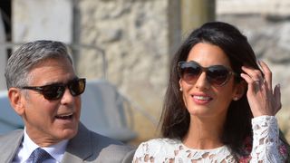US actor George Clooney and his wife Amal Alamuddin stand on a taxi boat on the Grand Canal on September 28, 2014 in Venice. Hollywood heartthrob George Clooney and Lebanese-British lawyer Amal Alamuddin married in Venice on Saturday September 27, 2014 before partying the night away with their A-list friends in one of the most high-profile celebrity weddings in years. "George Clooney and Amal Alamuddin were married today (September 27) in a private ceremony in Venice, Italy," Clooney spokesman Stan Rosenfield said. The announcement came as a surprise as the pair were not expected to officially tie the knot until Monday, though they are still tipped for a civil ceremony at the town hall to officialise the marriage under Italian law. AFP PHOTO / ANDREAS SOLARO (Photo credit should read ANDREAS SOLARO/AFP via Getty Images)
