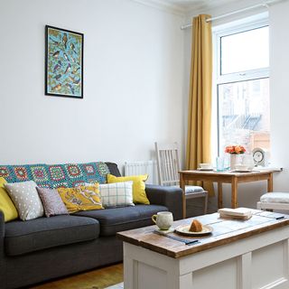 dining area with white wall and grey sofa