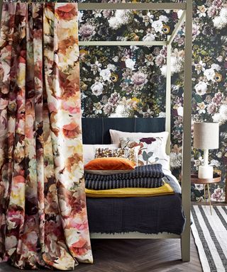 A bedroom with black floral wallpaper and a four poster bed