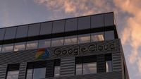 A close up of a building with the Google Cloud logo on the outside, with orange clouds in the background