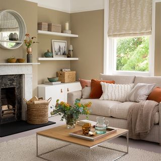 beige living room with neutral sofa and orange cushions