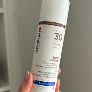 Laura holding Ultrasun SPF 30 Tan Activator - best sun creams