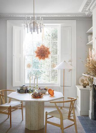 white dining room with round table decorated for christmas