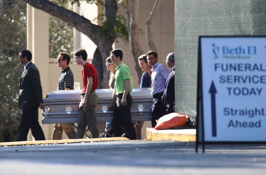 Parkland teacher Scott Beigel is carried to his final resting place