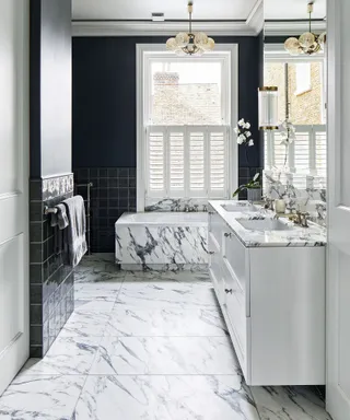 A bathroom with marble effect floor tiles and a marble effect bathtub