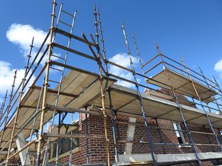 brick house being build with scaffolding