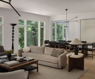 open plan living dining space with large windows and views of trees