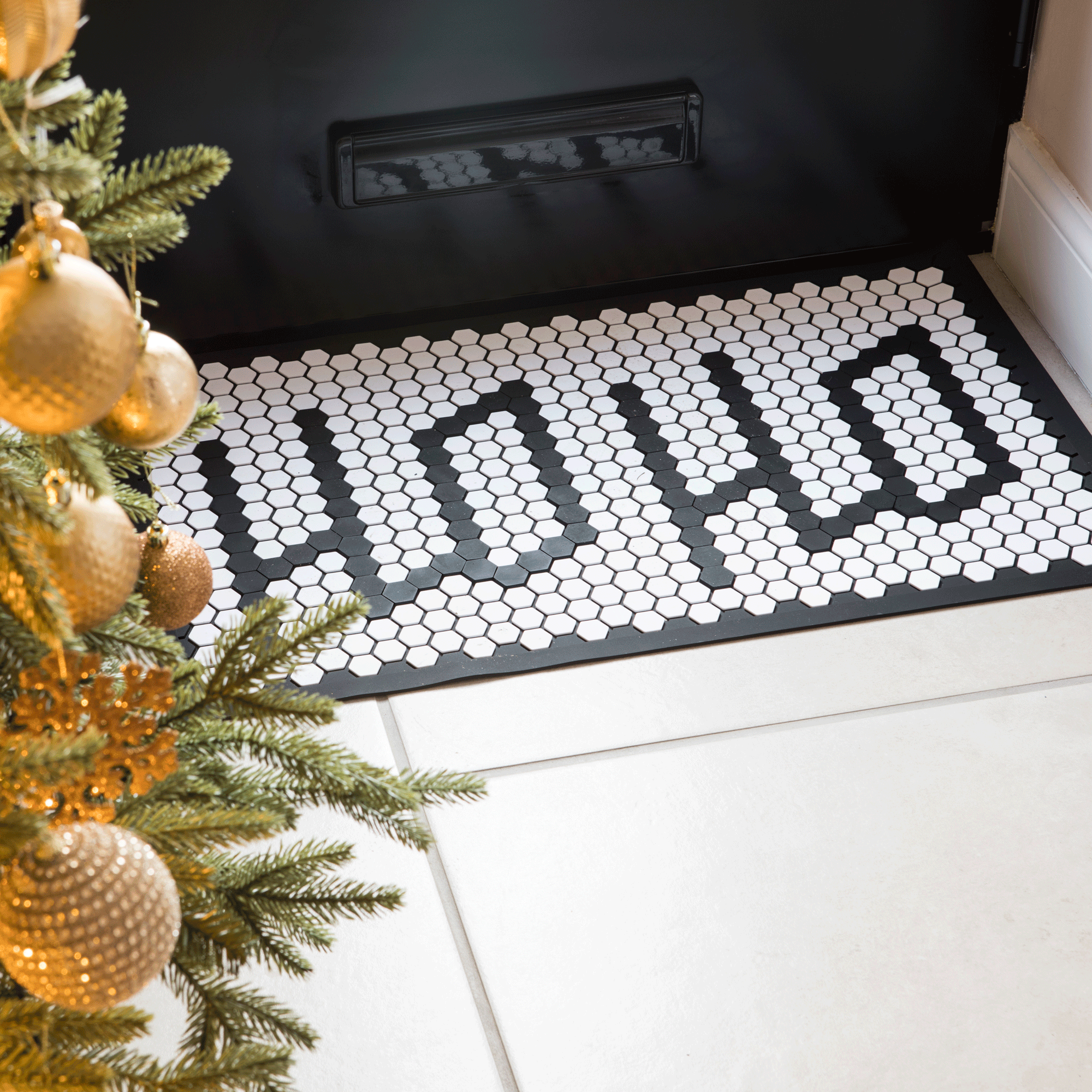 a festive monochrome doormat in a hallway