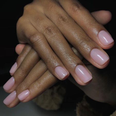 a close up picture of a pink manicure painted on squoval shaped nails
