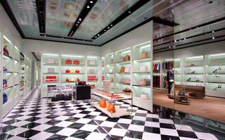 The women's areas feature 'Prada-green' fabric walls, mirrors and polished steel and crystal display counters