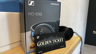 A pair of Sennheiser headphones in a box, with a 'Golden Ticket' in front of them