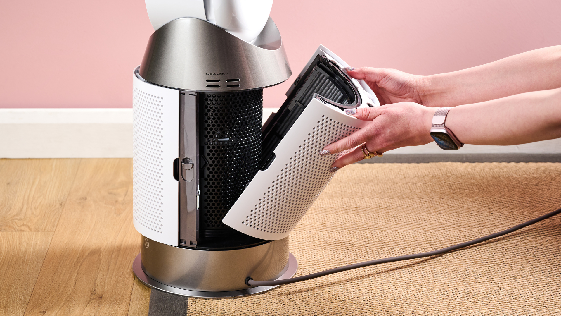 A woman is removing the outer shroud and air filter from the Dyson HP10.