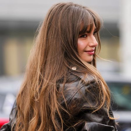 street style shot of woman with long brown hair and a fringe