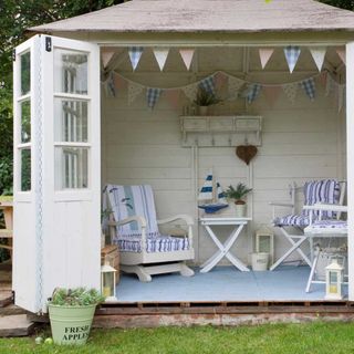 white shed with chairs and plant pot