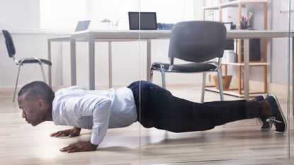 Man doing a push up micro workout in the office
