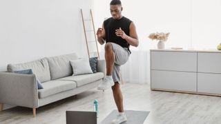 Young man doing standing ab crunches at home