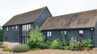 black timber clad barn conversion with double and single storey sections